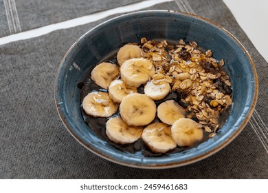 a bowl of healthy acai ice cream topped with banana oats and honey.  - Powered by Shutterstock