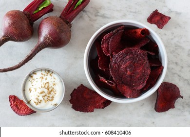 Bowl of healthy beet chips above view over a white marble background - Powered by Shutterstock