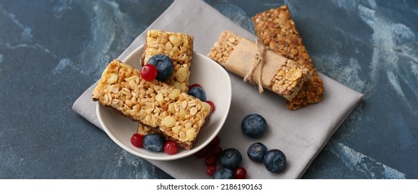 Bowl With Healthy Cereal Bars And Berries On Blue Background