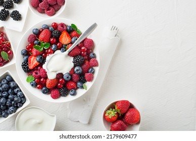 Bowl Of Healthy Fresh Berry Fruit Salad With Cream On White Background. Top View. Berries Overhead Closeup Colorful Assorted Mix Of Strawberry, Blueberry, Raspberry, Blackberry, Red Currant