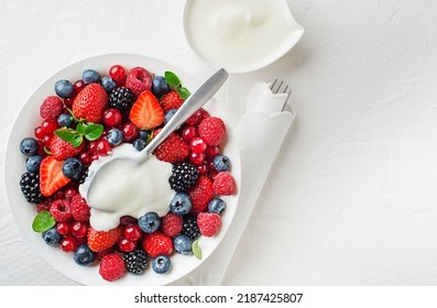 Bowl Of Healthy Fresh Berry Fruit Meal With Cream On White Background. Top View. Berries Overhead Closeup Colorful Assorted Mix Of Strawberry, Blueberry, Raspberry, Blackberry, Red Currant