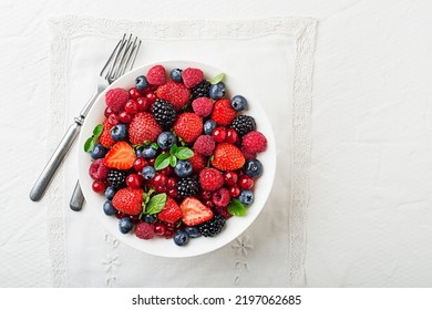 Bowl Of Healthy Fresh Berry Fruit Meal On White Table Background. Top View. Berries Overhead Closeup Colorful Assorted Mix Of Strawberry, Blueberry, Raspberry, Blackberry, Red Currant