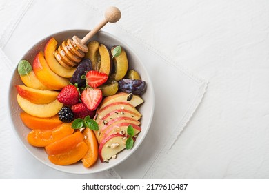 Bowl of healthy fresh fruit salad sweetened with honey on white background - Powered by Shutterstock