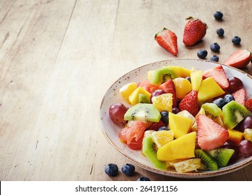 Bowl Of Healthy Fresh Fruit Salad On Wooden Background