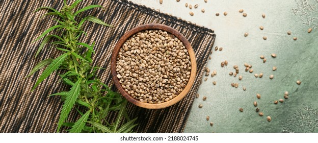 Bowl with healthy hemp seeds on grunge background