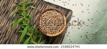 Bowl with healthy hemp seeds on grunge background