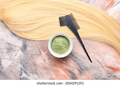 Bowl With Henna, Hair And Comb  On Color Background