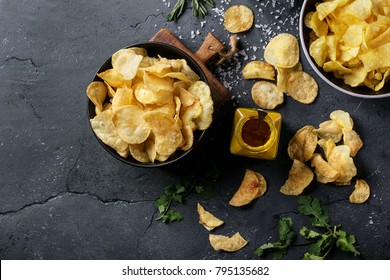 Bowl of home made potato chips served with mustard, rosemary, fleur de sel salt on stone background. Top view. Copy space - Shutterstock ID 795135682