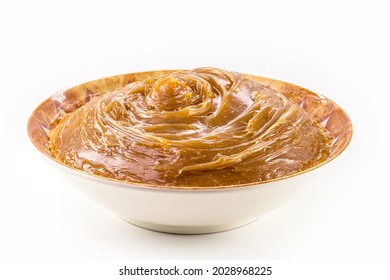 bowl with homemade dulce de leche, condensed cream or doughy caramel, isolated white background. - Shutterstock ID 2028968225