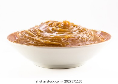 bowl with homemade dulce de leche, condensed cream or doughy caramel, isolated white background. - Shutterstock ID 2029571183