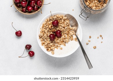 Bowl of homemade granola with nuts and cherry in white bowl on light background. Quick healthy breakfast - Powered by Shutterstock