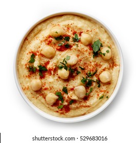 Bowl of homemade hummus isolated on white background from top view - Shutterstock ID 529683016
