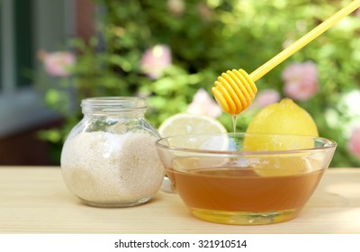 Bowl Of Honey And Sugar And Lemons On Wooden Table