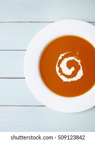 A Bowl Of Hot Tomato Soup On A Blue Wooden Kitchen Counter Background