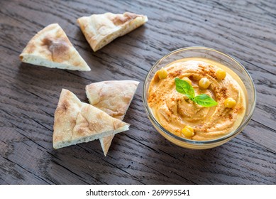 A Bowl Of Hummus With Pita Slices