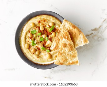bowl of hummus, top view - Shutterstock ID 1102293668