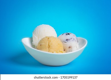 Bowl with ice cream balls with blue bacground.