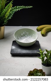 Bowl Of Icing Sugar Being Weighed In Preparation For Baking Banana Bread.