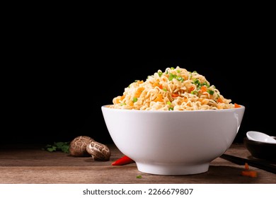 bowl of instant noodles or pasta. Delicious hot soup. Thai, Chinese, and Japanese food arranged on table isolated on black background. - Shutterstock ID 2266679807