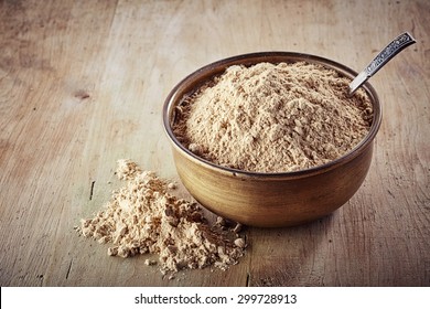 Bowl of maca powder  on wooden background
