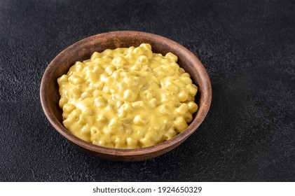 Bowl Of Macaroni And Cheese On Black Background