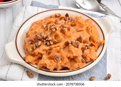 A Bowl Of Mashed Sweet Potatoes Close Up With Glazed Pecans