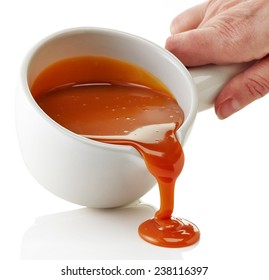 Bowl Of Melted Caramel Sauce Isolated On A White Background