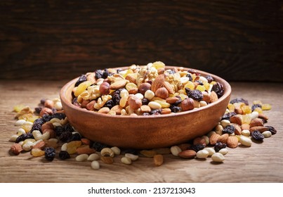 Bowl Of Mixed Nuts With Dried Fruits On Wooden Background