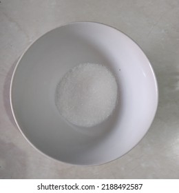 A Bowl Of MSG Ready To Use As Seasoning For Food With White Marble Background