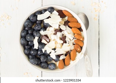 Bowl Of Oatmeal With Almond, Coconut Flakes And Blueberries, Top View.