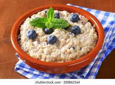 bowl of oatmeal with blueberries in the ceramic bowl with blue patterned linen - Powered by Shutterstock