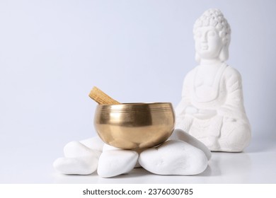 Bowl on stones and Buddha statue on white background, close up - Powered by Shutterstock