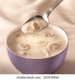 Bowl On A Table With Mushroom Soup And A Spoon Hovering Above