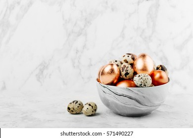 Bowl with painted bronze and quail  Easter eggs on a marble background.  - Powered by Shutterstock