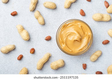 A bowl of peanut butter and whole peanuts arranged on a background. Horizontal. - Powered by Shutterstock