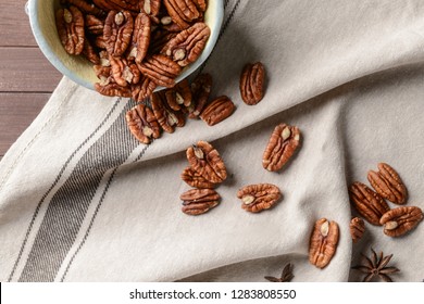 Bowl with pecan nuts on table