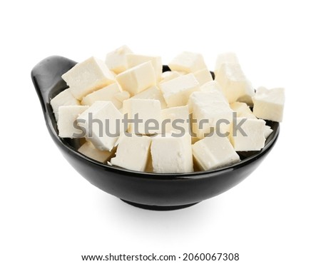 Bowl with pieces of feta cheese on white background