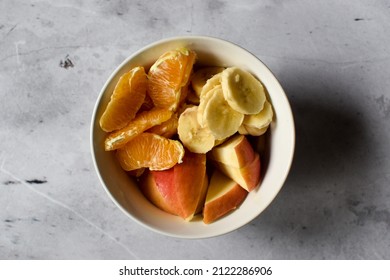 Bowl with pilled orange, banana and apple