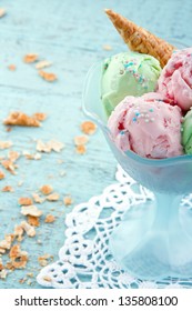 Bowl Of  Pink And Green Ice Cream With Sprinkles On Vintage Wooden Shabby Chic Background