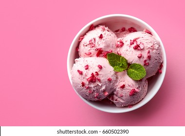 Bowl of pink strawberry ice cream isolated on pink background. Top view