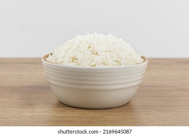 A Bowl Of Plain White Rice On A Wooden Table