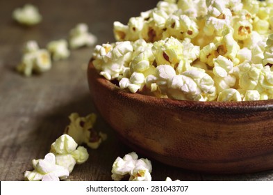 A Bowl Of Popcorn On A Wooden Table.