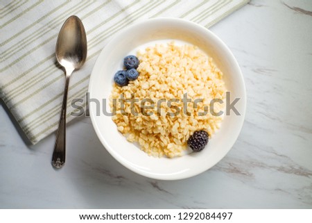 Bowl of popped rice breakfast cereal with milk blueberries and raspberries