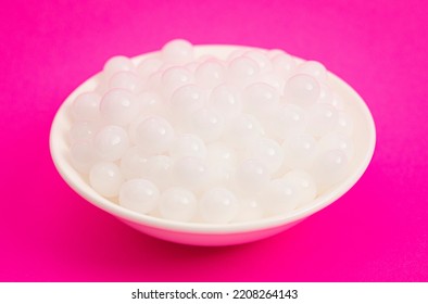 A Bowl Of Popping Boba Pearls On A Bright Pink Background