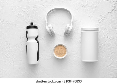 Bowl With Protein Powder, Bottle, Jar And Headphones On White Background