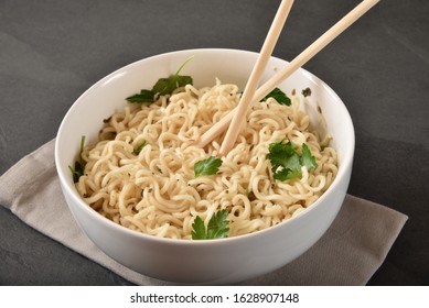 A Bowl Of Raman Noodles With Fresh Cilantro And Chopsticks