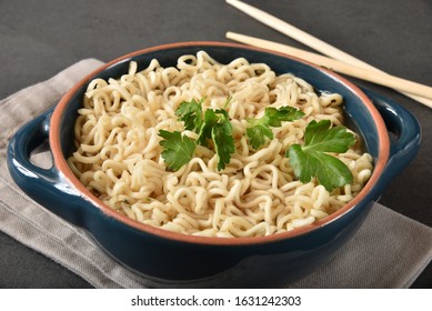 A Bowl Of Raman Noodles With Italian Parsley And Chop Sticks