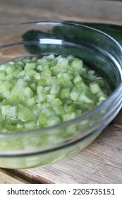 A Bowl Of Raw Cucumber Pickled And Two Cucumbers On A Wooden Table Portrait