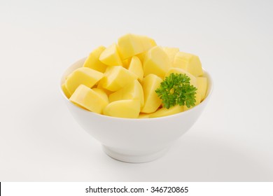 bowl of raw diced potatoes on white background