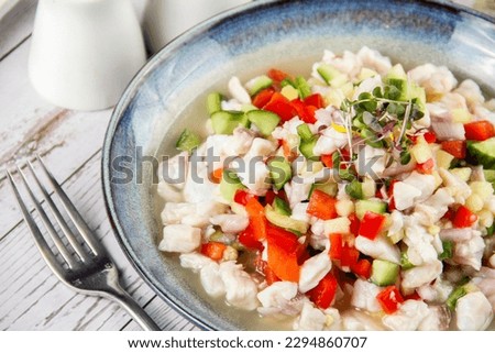 bowl of red snapper ceviche with fork  in the wooden background, close-up 